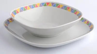 a white bowl with a colorful rim on a plate at Anakob in Aswan
