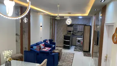 a living room with a blue couch and a kitchen at Apartment in Center of Hurghada in Hurghada