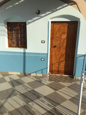 two wooden doors in a room with a tile floor at The Brown House in Luxor