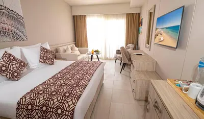 a hotel room with a large bed and a desk at Amarina Abu Soma Resort & Aquapark in Hurghada