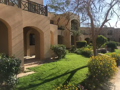 a courtyard of a house with grass and flowers at One bedroom Apt at The View - B104 in Hurghada