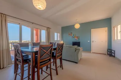 a dining room with a table and chairs and a couch at Golden Apartments El Gouna in Hurghada