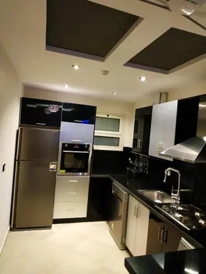 a kitchen with a stainless steel refrigerator and a sink at Elite Suites Hurghada in Hurghada