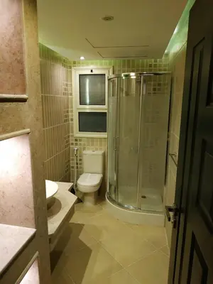 a bathroom with a toilet and a glass shower at Elite Suites Hurghada in Hurghada