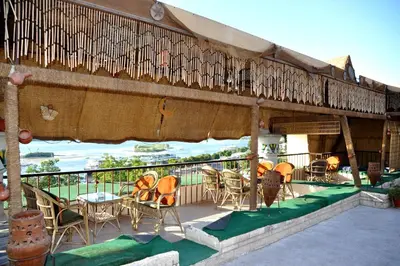 a patio with chairs and tables on a balcony at Marhaba Palace Hotel in Aswan