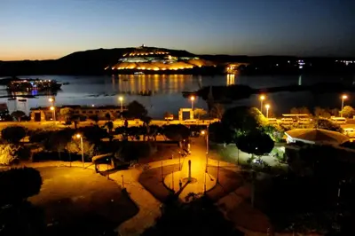 a view of a lake at night with a building at Marhaba Palace Hotel in Aswan