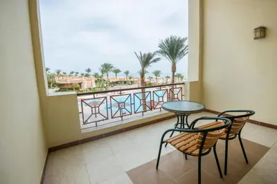 a balcony with a table and two chairs and a window at Imperial Shams Abu Soma in Hurghada