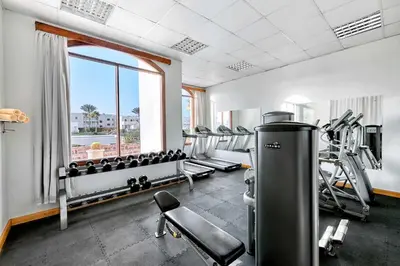 a gym with treadmills and machines and a window at JAZ Neo Reef Marsa in Coraya Bay