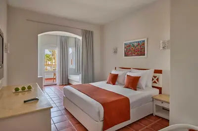 a hotel room with a large bed and a table at JAZ Neo Reef Marsa in Coraya Bay
