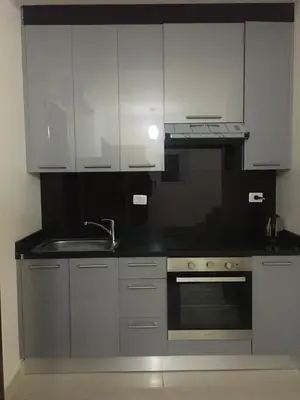 a kitchen with white cabinets and a sink and a stove at Pool View one bedroom at Hurghada - B101 in Hurghada