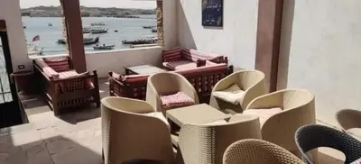 a restaurant with chairs and a view of the water at Villa Misk in Aswan
