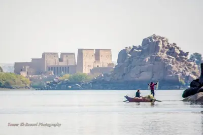two people on a boat in the water with a castle at Villa Misk in Aswan