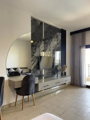 a living room with a television and a chair at AlDau Heights Apartments in Hurghada