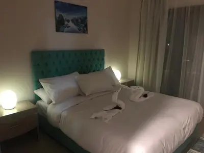 a bedroom with a white bed with a green headboard at Hurghada Furnished Appratment - Al Dau Hights Al Mamsha in Hurghada