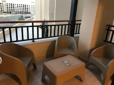 a room with chairs and a table and a balcony at Hurghada Furnished Appratment - Al Dau Hights Al Mamsha in Hurghada