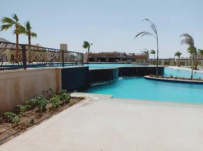 a swimming pool with blue water and palm trees at Hurghada Furnished Appratment - Al Dau Hights Al Mamsha in Hurghada