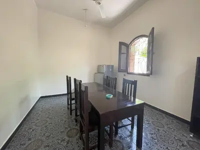 a dining room with a table and chairs and a window at Gîte Hôtel Ramla Louxor in Luxor