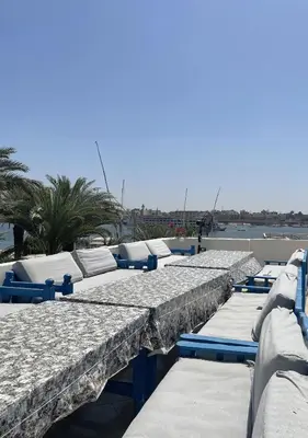 a row of beds on a pier next to the water at Gîte Hôtel Ramla Louxor in Luxor