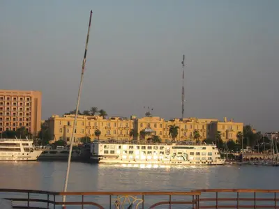 a large white boat in the water next to buildings at Gîte Hôtel Ramla Louxor in Luxor