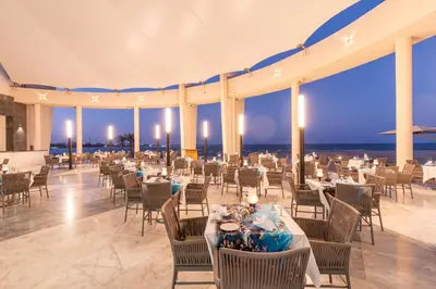 a banquet hall with tables and chairs and the ocean at Malikia Resort Abu Dabbab in Abu Dabab