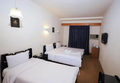 a hotel room with two beds and a television at Cleopatra Hotel in Aswan