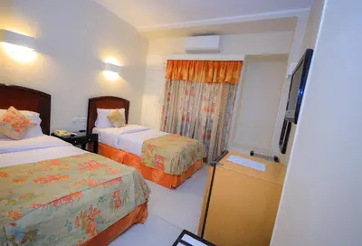 a hotel room with two beds and a television at Cleopatra Hotel in Aswan