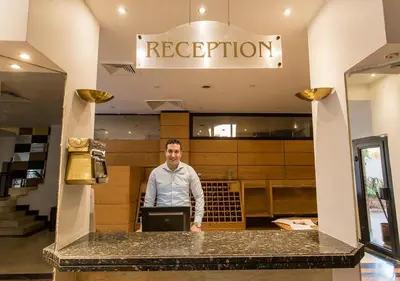 a man standing at a counter in a restaurant at Cleopatra Hotel in Aswan