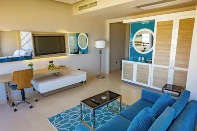 a living room with a blue couch and a desk at Gravity Hotel & Aqua Park Sahl Hasheesh Families and Couples Only in Hurghada