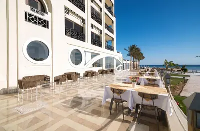 a restaurant with tables and chairs on the side of a building at Gravity Hotel & Aqua Park Sahl Hasheesh Families and Couples Only in Hurghada
