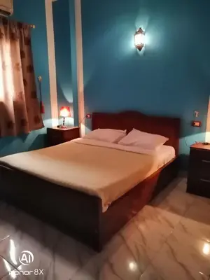 a bed in a bedroom with a blue wall at Al Hambra Hotel in Luxor