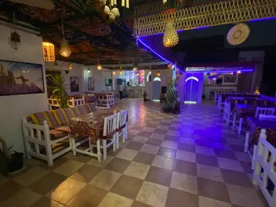 a room with a table and chairs and purple lights at El Gezira Hotel in Luxor