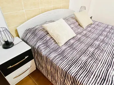 a bed with a black and white striped blanket on it at Zebra House Hurghada center in Hurghada