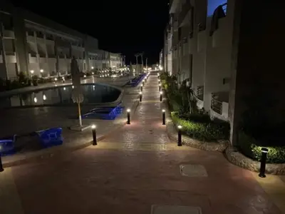 a courtyard with a swimming pool at night with lights at Chalet in Cecelia Resort in Hurghada