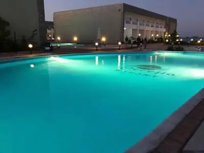 a large pool with blue lights in front of a building at Chalet in Cecelia Resort in Hurghada