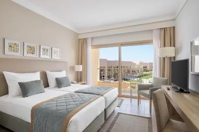 a bedroom with a bed and a desk and a television at JAZ Elite Maraya in Coraya Bay