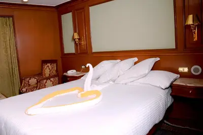 a hotel room with a bed with a swan on it at Nile Cruise Luxor Aswan 3,4 and 7 nights in Aswan