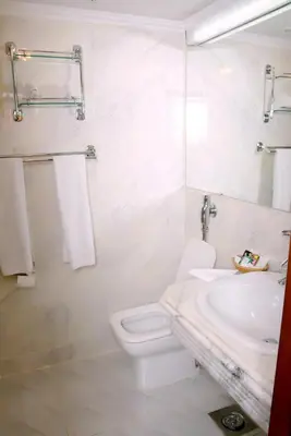 a white bathroom with a toilet and a sink at Nile Cruise Luxor Aswan 3,4 and 7 nights in Aswan