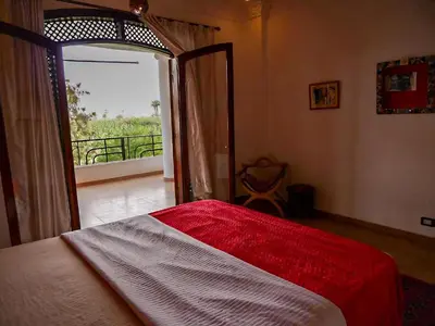 a bedroom with a bed and a door to a balcony at Villa Quiet Place in Luxor
