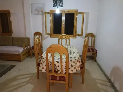 a dining room with a table and chairs and a window at Adad Noubian House in Aswan