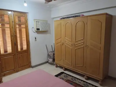 a bedroom with a large wooden cabinet and a fan at Adad Noubian House in Aswan