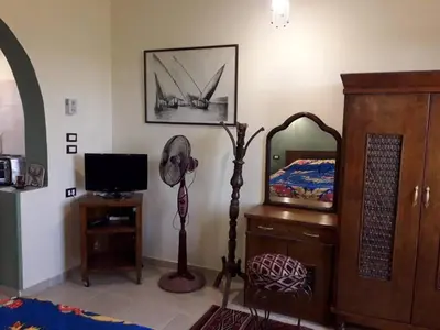 a room with a fan and a mirror and a bed at Villa Bahri Luxor Apartment in Luxor