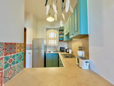a kitchen with blue cabinets and a refrigerator at Lagoon view 1-bedroom apartment in West Golf El Gouna in Hurghada