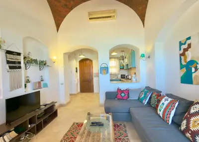 a living room with a blue couch and a tv at Lagoon view 1-bedroom apartment in West Golf El Gouna in Hurghada