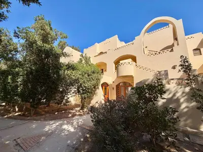 a large white building with trees in front of it at Lagoon view 1-bedroom apartment in West Golf El Gouna in Hurghada