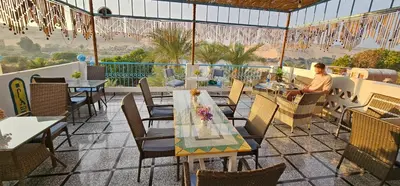 a restaurant with tables and chairs on a patio at Basmatic Nubian Guest House in Aswan