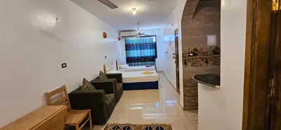 a small room with a bedroom with a bed and a table at Basmatic Nubian Guest House in Aswan