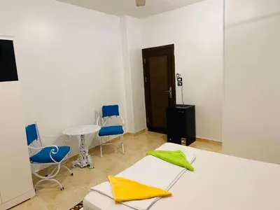 a room with two beds and a table and chairs at Basmatic Nubian Guest House in Aswan