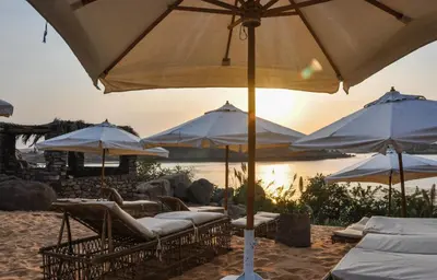 a group of chairs and umbrellas on a beach at Eco Nubia in Aswan