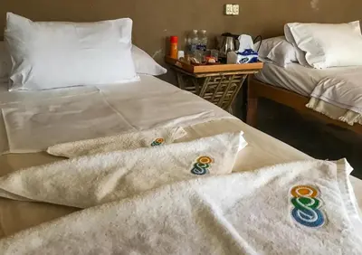 two beds in a room with towels on them at Eco Nubia in Aswan
