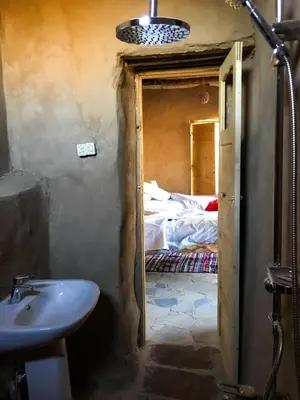 a bathroom with a sink and a room with a bed at Eco Nubia in Aswan